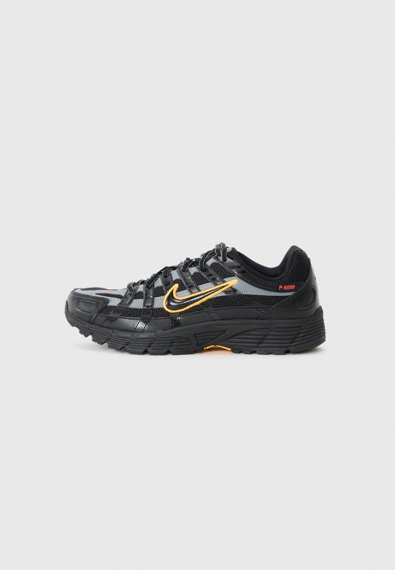Des chaussures de sport noires avec une tige en mesh et en synthétique, des accents réfléchissants, un logo swoosh orange et une semelle extérieure en caoutchouc texturé.