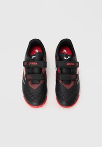 Scarpe sportive nere e rosse con superficie testurizzata, doppie cinghie in velcro e logo bianco a contrasto. Punta arrotondata e suole imbottite.