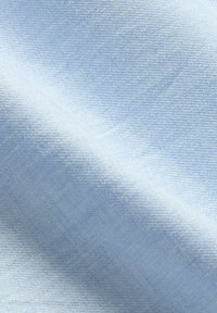 Tessuto blu chiaro con una trama liscia, che presenta un sottile motivo a tessitura diagonale. La superficie è leggermente lucida e uniforme.