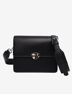 Melna ādas plecu soma ar platu dizainu, sudraba vairogs formas metāla detaļām, regulējamu siksnu un gludu tekstūru.