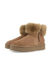 Botas de tobillo de ante beige con un suave cuello de piel, cierre lateral con cremallera y suela de goma plana. Textura suave y diseño simple.