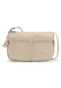 Béžová látková crossbody taška s dvěma předními zip kapsami, logem na nášivce, nastavitelným popruhem a dekorativním přívěskem na klíče.
