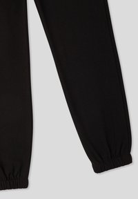 Czarne dresowe spodnie z elastycznym paskiem w talii i marszczonymi mankietami, wykonane z gładkiego, miękkiego materiału, o prostym, minimalistycznym designie.