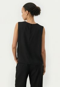 Top senza maniche nero con una texture liscia, caratterizzato da un collo rotondo e una piccola chiusura a bottone sulla schiena. Design semplice e minimalista.
