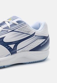 Witte sportieve schoen met blauwe accenten, voorzien van een ademend mesh bovenwerk, een gestructureerd ontwerp en een gevoerde zool voor ondersteuning.