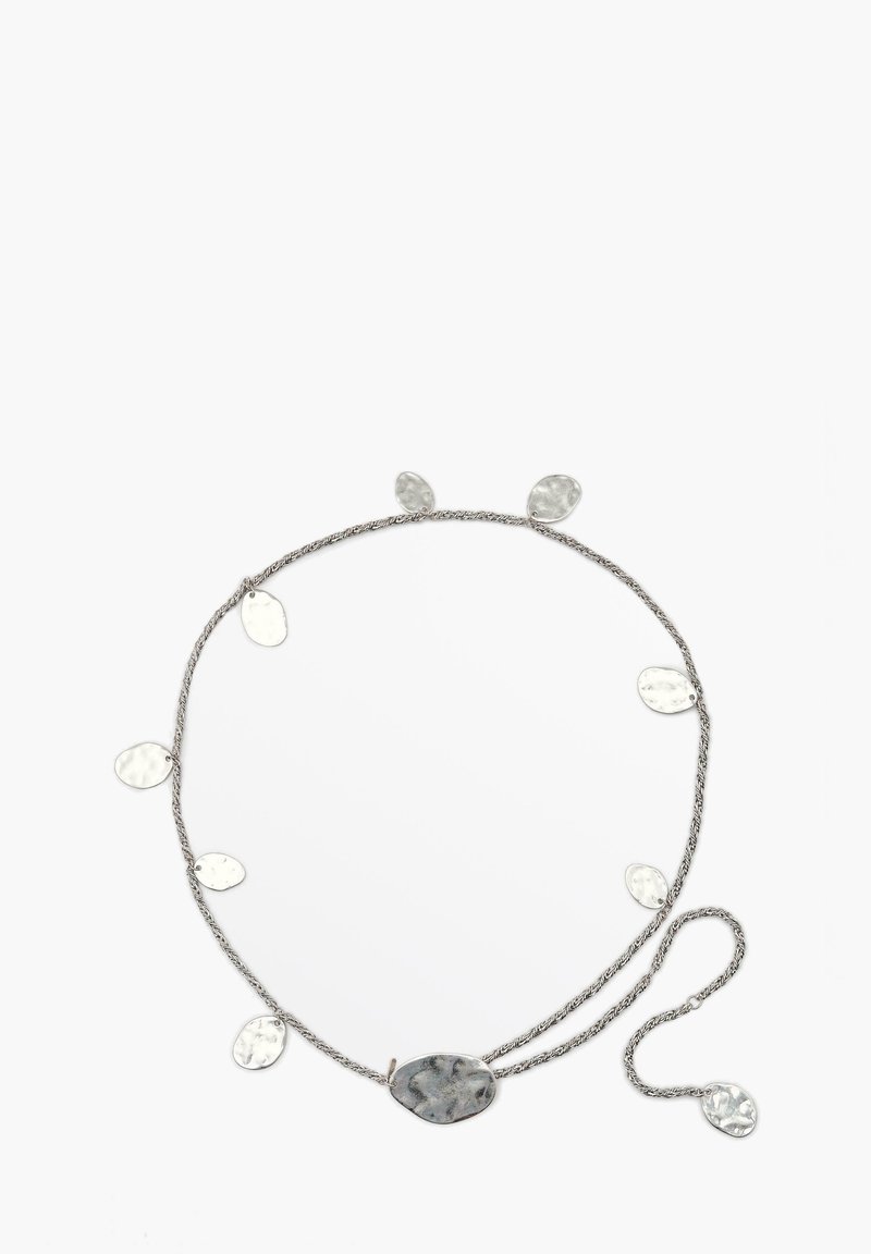 Silver twisted chain necklace with multiple oval metallic accents in varying sizes and a central larger oval pendant with a textured surface.