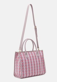 Strukturhandväska i ljusrosa med ett geometriskt mönster av röda och marinblå chevroner. Har dubbla handtag och ett justerbart axelrem.