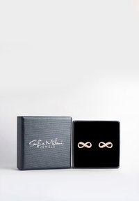 Svart smyckeskrin med Sofia Milani Jewels-logotyp, som innehåller ett par örhängen i form av en guld-infinitysymbol med små inbäddade stenar.