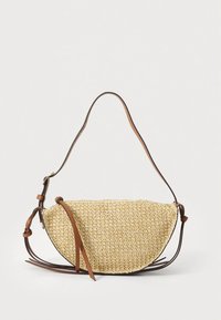 Vevd stråhåndveske med buet form, lys tanfarge, brun lærreim og flat bunn; har naturlig tekstur og enkelt design.