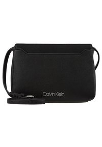 Černá crossbody kabelka Calvin Klein vyrobená z texturovaného syntetického materiálu, navržená v minimalistickém stylu a ozdobená stříbrným logem. Nastavitelný popruh.
