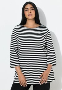Czarna i biała bluzka w paski z dekoltem typu łódka, rękawami długości do łokcia oraz ozdobnymi detalami przy szyi. Miękka tkanina, luźny fason.