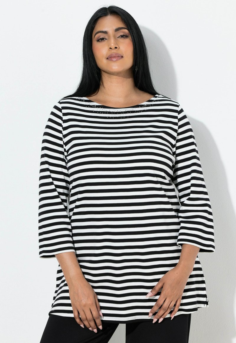 Czarna i biała bluzka w paski z dekoltem typu łódka, rękawami długości do łokcia oraz ozdobnymi detalami przy szyi. Miękka tkanina, luźny fason.