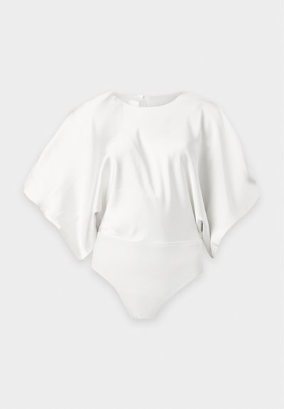 Body blanc à manches larges et fluides avec un col rond, présenté sur un fond neutre.