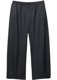 Zwarte brede broek van lichtgewicht stof. Heeft een elastische tailleband met een trekkoord en zijzakken voor functionaliteit.