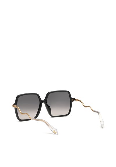 Lunettes de soleil carrées noires avec verres dégradés et branches métalliques dorées ondulées se terminant par des embouts en plastique transparent avec des détails dorés.
