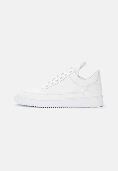 White low-top sneaker with lace-up closure, stitched detailing, pull tab at heel, and a ridged sole on a plain light background.