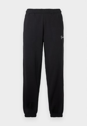 Calças de fato pretas com um cós elástico, aberturas de perna ajustadas e um discreto logotipo branco na coxa esquerda. Feitas de um tecido suave.