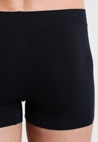Black cotton boxer briefs with a soft texture, close-fitting design, and elastic waistband, featuring clean stitching and no visible patterns.