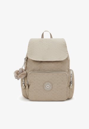 Beige patterned Kipling backpack with front and side zip pockets, top flap, and a small plush monkey keychain attached to left side zipper.