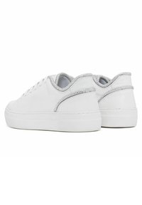 Valkeat tennarit, joissa on teksturoitu pinta, sileä päällinen, hopeinen yksityiskohta kantapäässä ja perinteinen nauhakiinnitys.