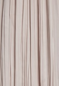 Tessuto plissato in un morbido color blush, caratterizzato da linee verticali e una consistenza liscia, che crea un aspetto leggero e fluido.