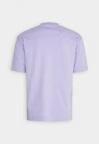 T-shirt à manches courtes en tissu lavande clair, avec un col rond et un design simple et sans couture, sans graphiques ni logos visibles.