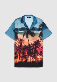 Camicia a maniche corte con silhouette di palma contro un tramonto arancione, con la parte superiore blu. Realizzata in tessuto leggero, design con bottoni.