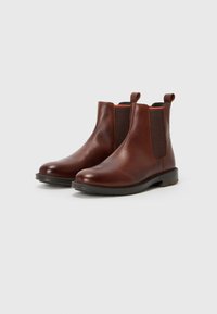 Bruine leren chelsea boots met elastische zijpanelen en trekriempjes. Ronde neus, textuur op het oppervlak en een duurzame rubberen zool.