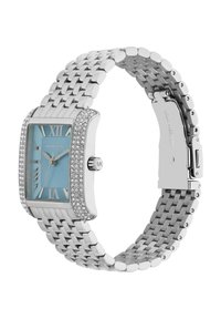 Orologio in metallo argentato con una lunetta rettangolare scintillante e un quadrante blu chiaro. Presenta numeri romani e un cinturino texturizzato. Marchiato "Michael Kors."
