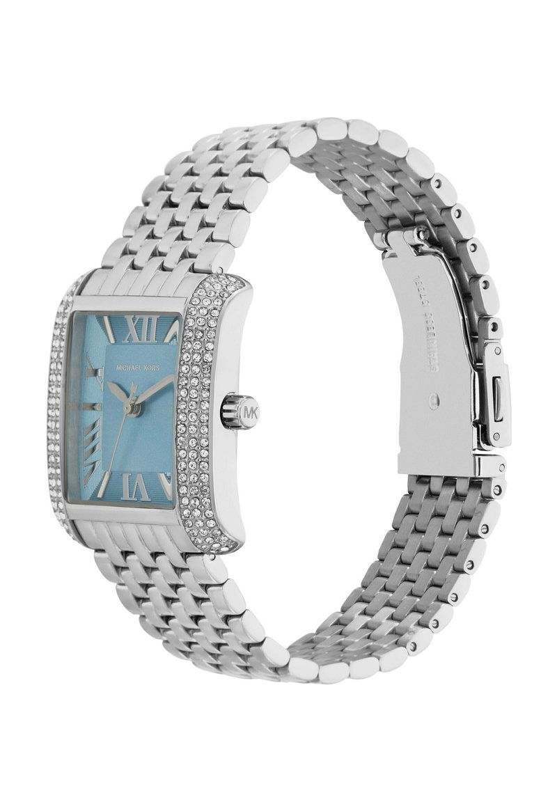 Orologio in metallo argentato con una lunetta rettangolare scintillante e un quadrante blu chiaro. Presenta numeri romani e un cinturino texturizzato. Marchiato "Michael Kors."
