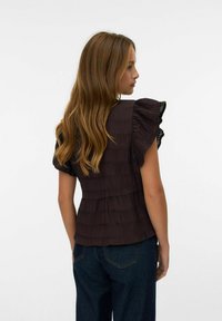Top plissettato marrone scuro con maniche arricciate, che mostra un design testurizzato. Il tessuto è leggero, con una vita aderente e un orlo svasato.