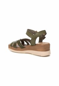 Sandalia cuña de cuero verde oliva con múltiples tiras entrecruzadas, plantilla texturizada, base de plataforma de madera y suela de goma ligera.