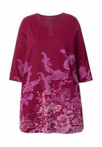 Bordeauxfarbene Tunika mit ¾-Ärmeln, die lila Paisley- und Blumenmuster zeigt. Weicher Stoff, runder Ausschnitt mit einem kleinen Schlüsselauschnitt.