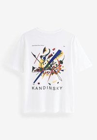 Valkoinen lyhythihainen t-paita, jossa on abstrakti värimuotoilu, jossa on muotoja ja viivoja. "KANDINSKY" -teksti painettuna alaosaan.