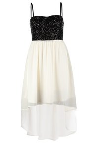 Corsage noir ajusté à sequins avec fines bretelles et jupe fluide en chiffon blanc à ourlet haut-bas.