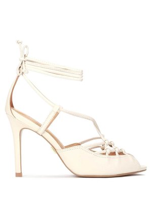 Beżowa sandał na wysokim obcasie z wiązaniami na kostce, odkrytym palcem, wiązanymi paskami z przodu oraz smukłym obcasem typu stiletto.