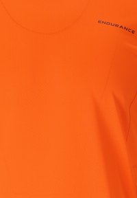 Oranssi urheilupaita, jossa on tekstuurinen pinta, pyöreä pääntie ja sana "KESTÄVYYS" painettuna sivulle.