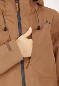 Brun zip-up jacka med en texturerad yta, som har en frontficka, justerbar huva och svarta dragsko för en säker passform.