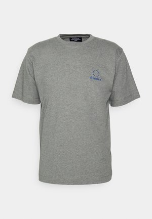 Camiseta de algodón gris con mangas cortas, cuello redondo y diseño de logo azul estampado en el área del pecho izquierdo. Estilo simple, sin adornos.