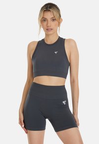 Tamno sivi sportski crop top i kratke hlače visokog struka, sa bešavnim dizajnom i malim bijelim logom na lijevoj strani.