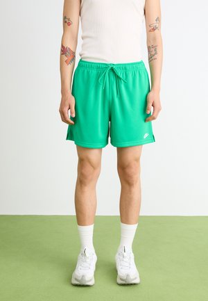 Zelene sportske kratke hlače s elastičnim pojasom i stranim prorezima, izrađene od lagane tkanine. Logo Nike vidljiv u donjem desnom kutu.