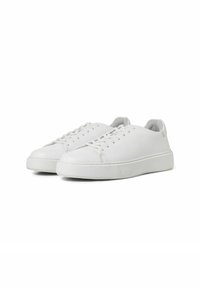 Baskets en cuir blanc avec bout rond, semelle texturée et lacets plats. Surface lisse avec un design minimaliste et sans marque visible.