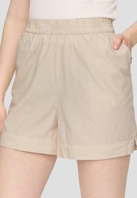 Beige gestreifte Shorts mit einem elastischen Bund, seitlichen Taschen und einer lockeren Passform. Die glatte Textur und die dezenten Streifen verleihen zusätzlichen Charme.