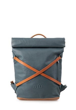Blauwe rugzak met een oprolbare bovenkant, bruine leren kruisbanden, een bovenste handvat, een zijritszak en een geperst "a/u"-logo aan de voorkant.