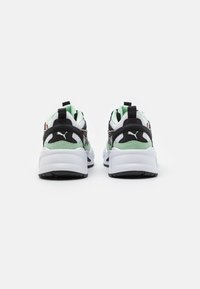 Puma RS-X Sneakers in einer schwarz-weißen und mintgrünen Farbgebung, aus Mesh- und synthetischen Materialien, mit gepolstertem Schaft und auffälligem Branding an der Ferse.