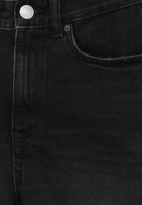 Zwarte denim jeans met een klassiek vijf-pocket ontwerp, zilveren knoopophang materiaal en een subtiele textuurafwerking. Rafelige rand van de zak is zichtbaar.