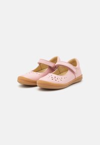 Par de zapatos infantiles tipo Mary Jane en color rosa, con patrones florales perforados, correas ajustables y suelas de goma marrón texturizadas.