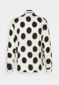 Langärmliges Hemd mit einem Muster aus schwarzen und cremefarbenen Punkten, glatter Textur und klassischem Kragen.