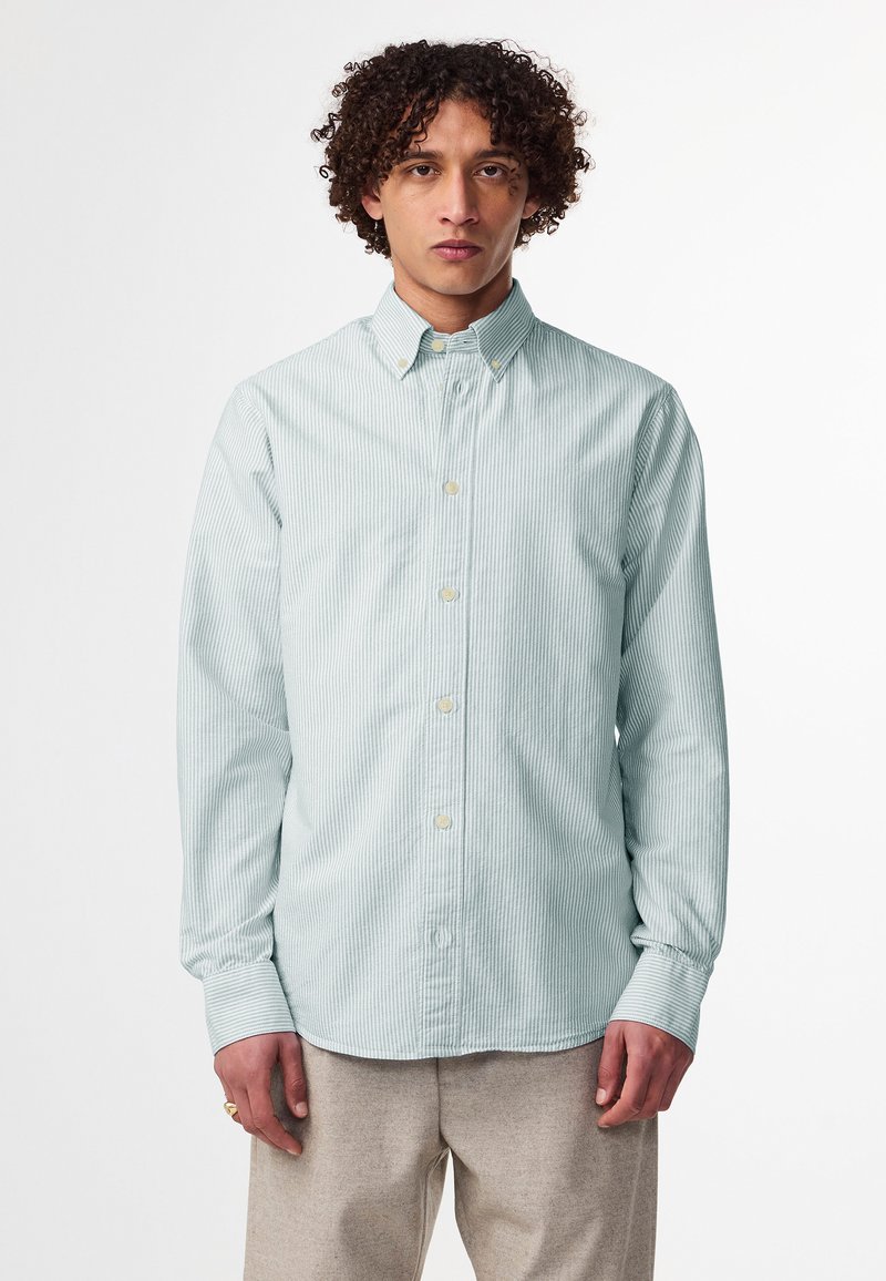 Camicia a righe verde chiaro con bottoni, realizzata in cotone. Presenta un colletto classico, maniche lunghe e bottoni beige. Texture morbida e liscia.