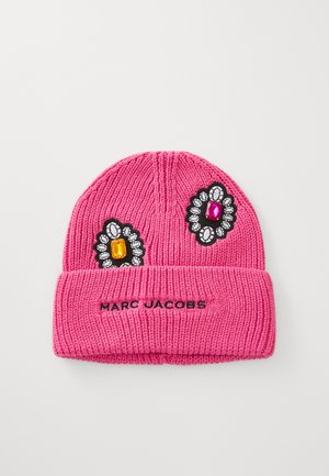 Roza pletena kapa z zavihkom, okrašena z rumenimi in roza draguljnimi aplikacijami ter z napisom "Marc Jacobs" izvezenim v črni barvi na zavihku.